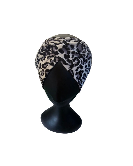 Leopard print headscarf on a black mannequin head against a white background