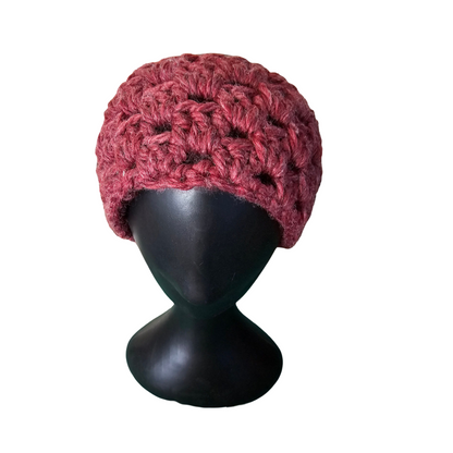 Red knitted beanie on a black mannequin head against a white background