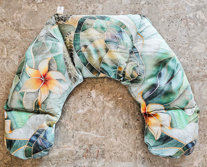 Hot and Cold neck pack with a tropical floral and leaf pattern in shades of green, beige, and orange, laid flat on a textured stone surface.