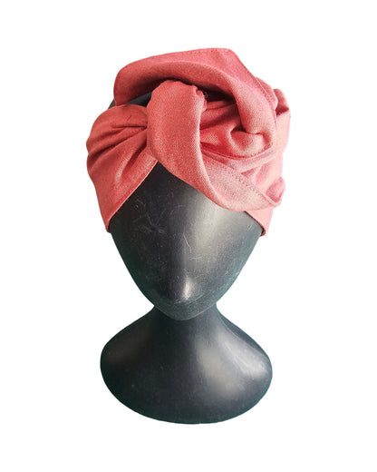 Pink turban on a mannequin head against a white background