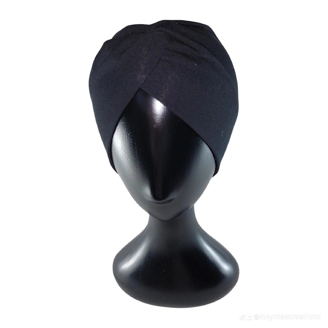 Black turban on a mannequin head against a white background
