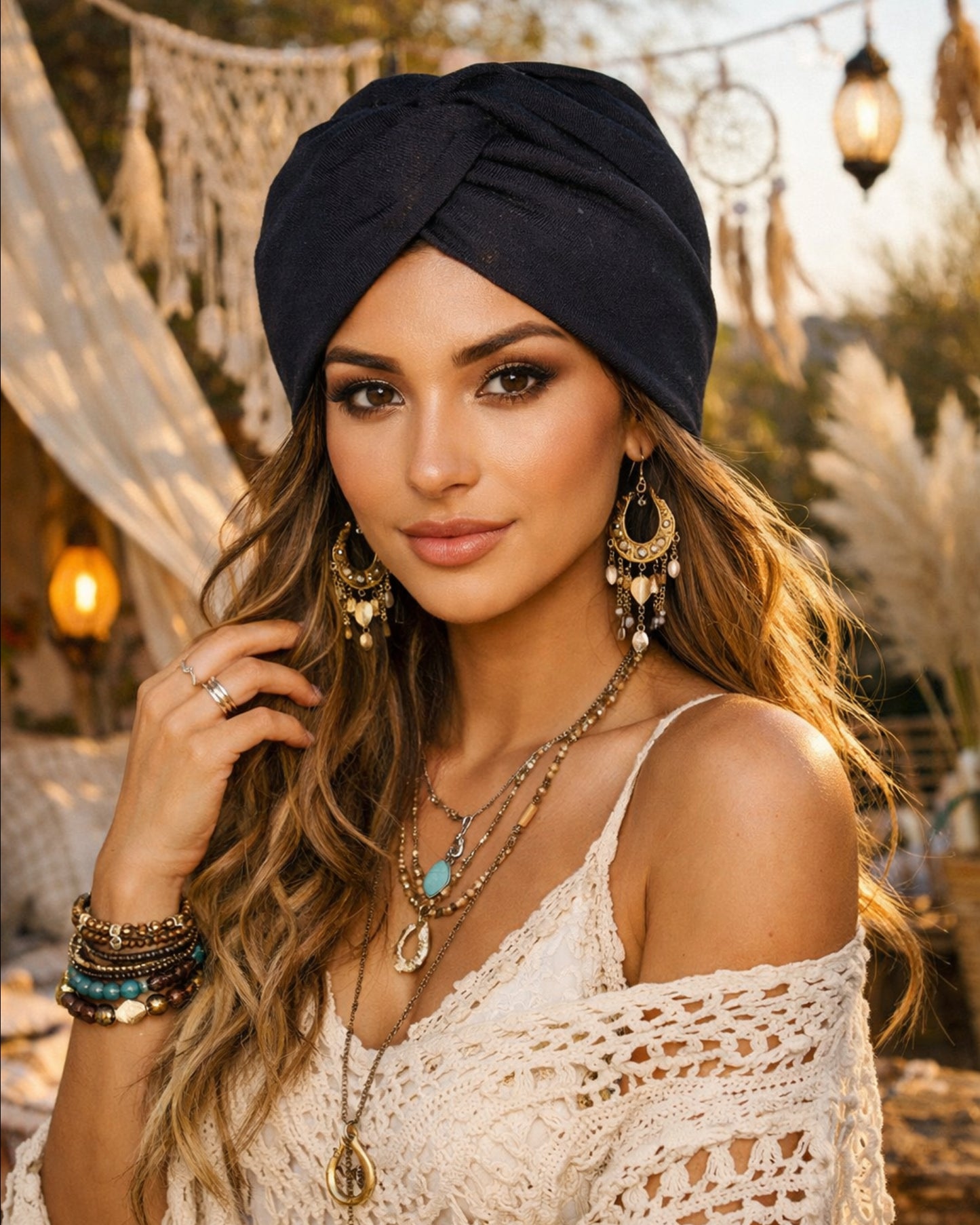 Woman wearing a black turban and bohemian jewelry in an outdoor setting