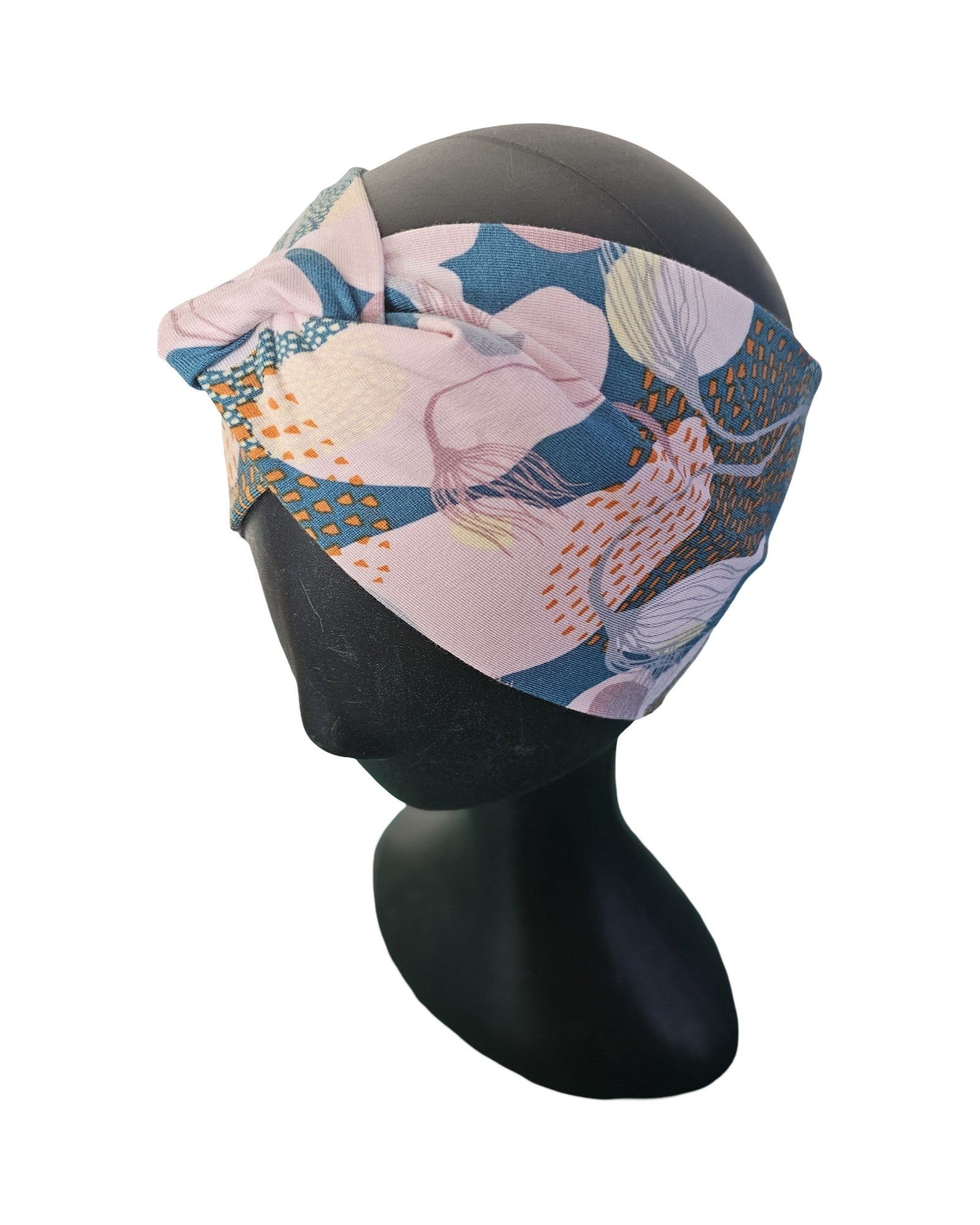 Colorful headscarf with floral pattern on a black mannequin head against a white background