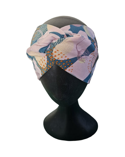 Colorful headband with floral pattern on a black mannequin head against a white background