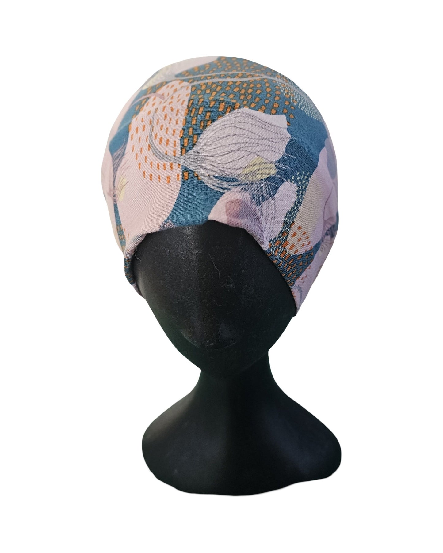 Colorful headscarf on a black mannequin head against a white background