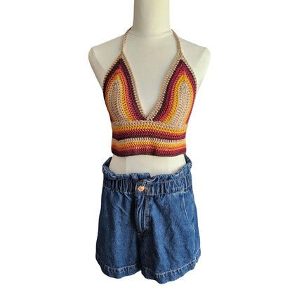 Mannequin wearing a colorful crochet top and denim shorts on a white background