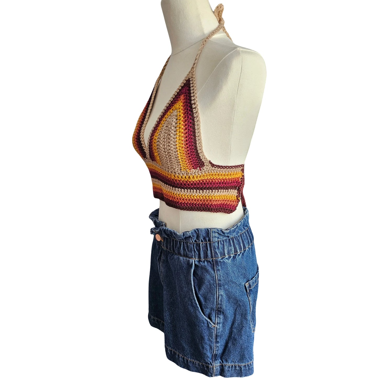 Mannequin wearing a colorful striped crochet top and blue denim shorts on a white background