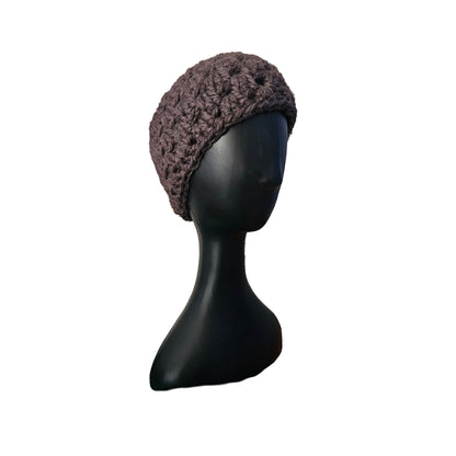 Knitted brown beanie on a black mannequin head against a white background