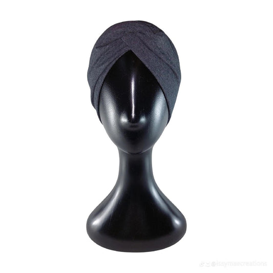 Black turban on a black mannequin head against a white background