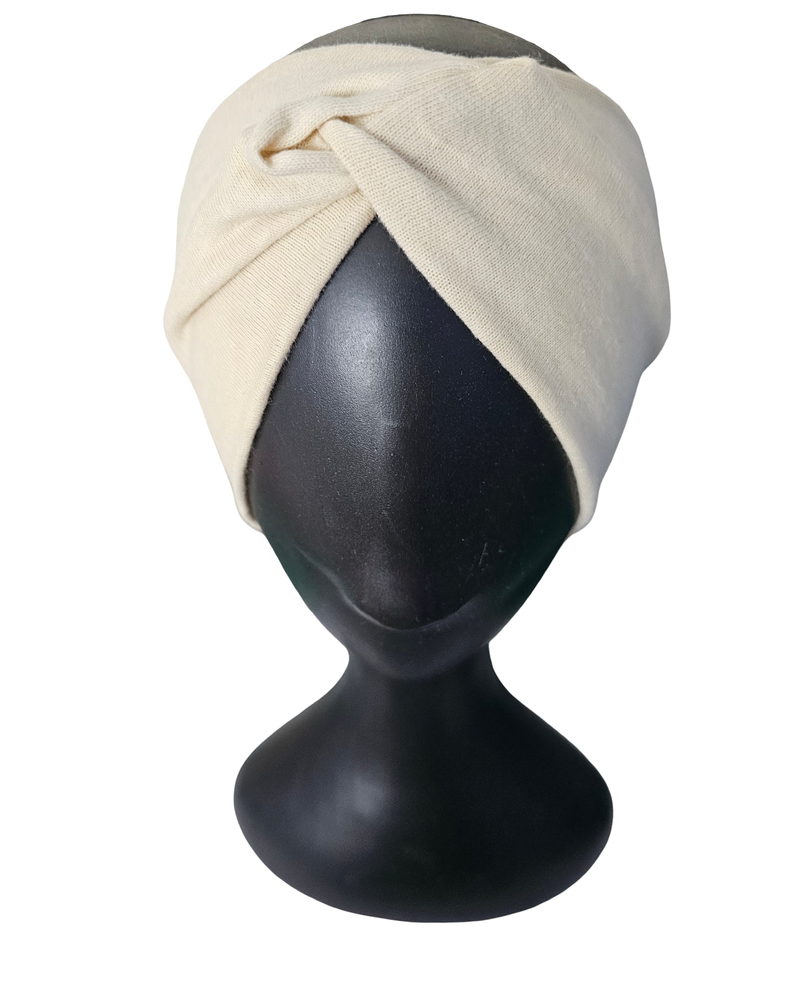 Beige headscarf on a black mannequin head against a white background