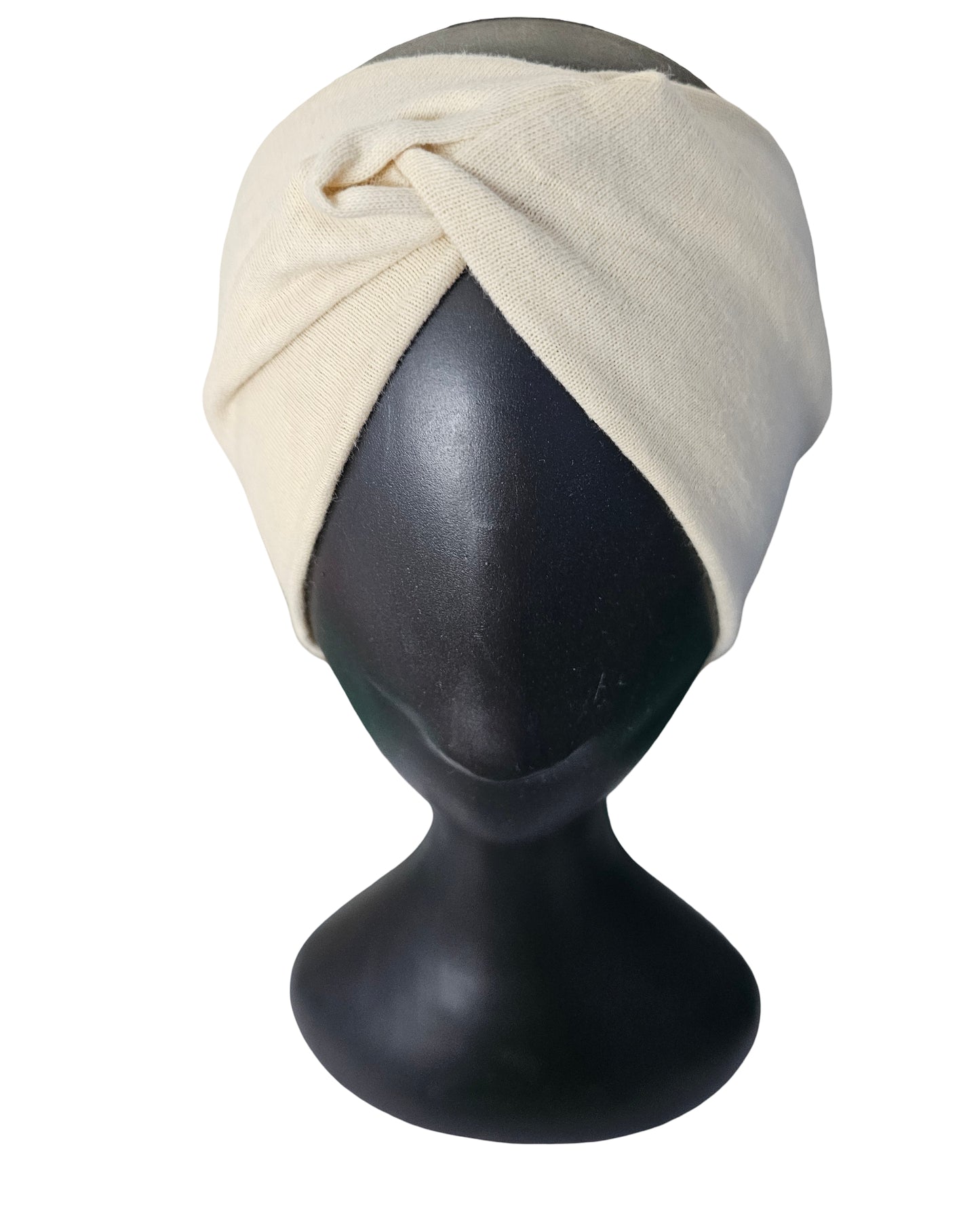 Beige headscarf on a black mannequin head against a white background