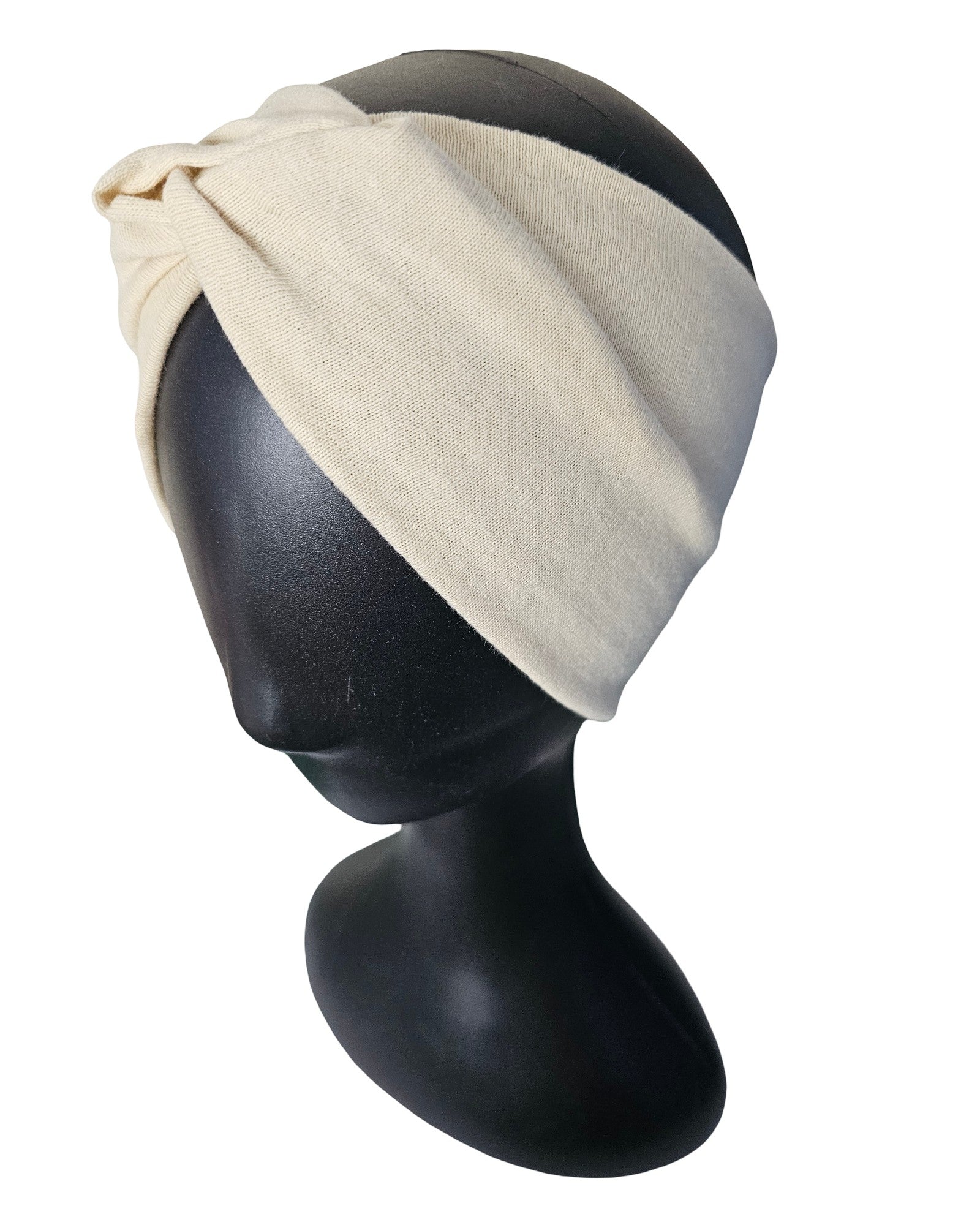 Beige headscarf on a black mannequin head against a white background