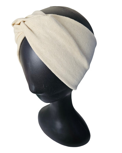Beige headscarf on a black mannequin head against a white background