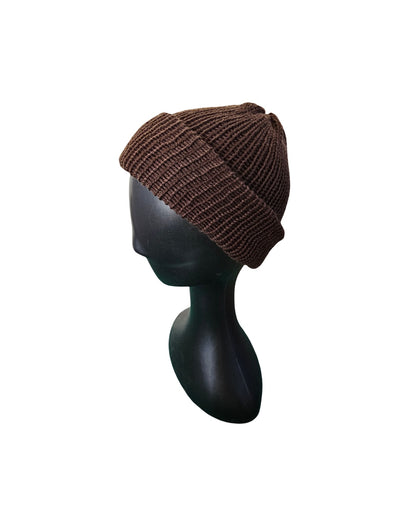 Brown knit beanie on a black mannequin head against a white background