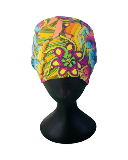 Colorful patterned headband on a black mannequin head against a white background
