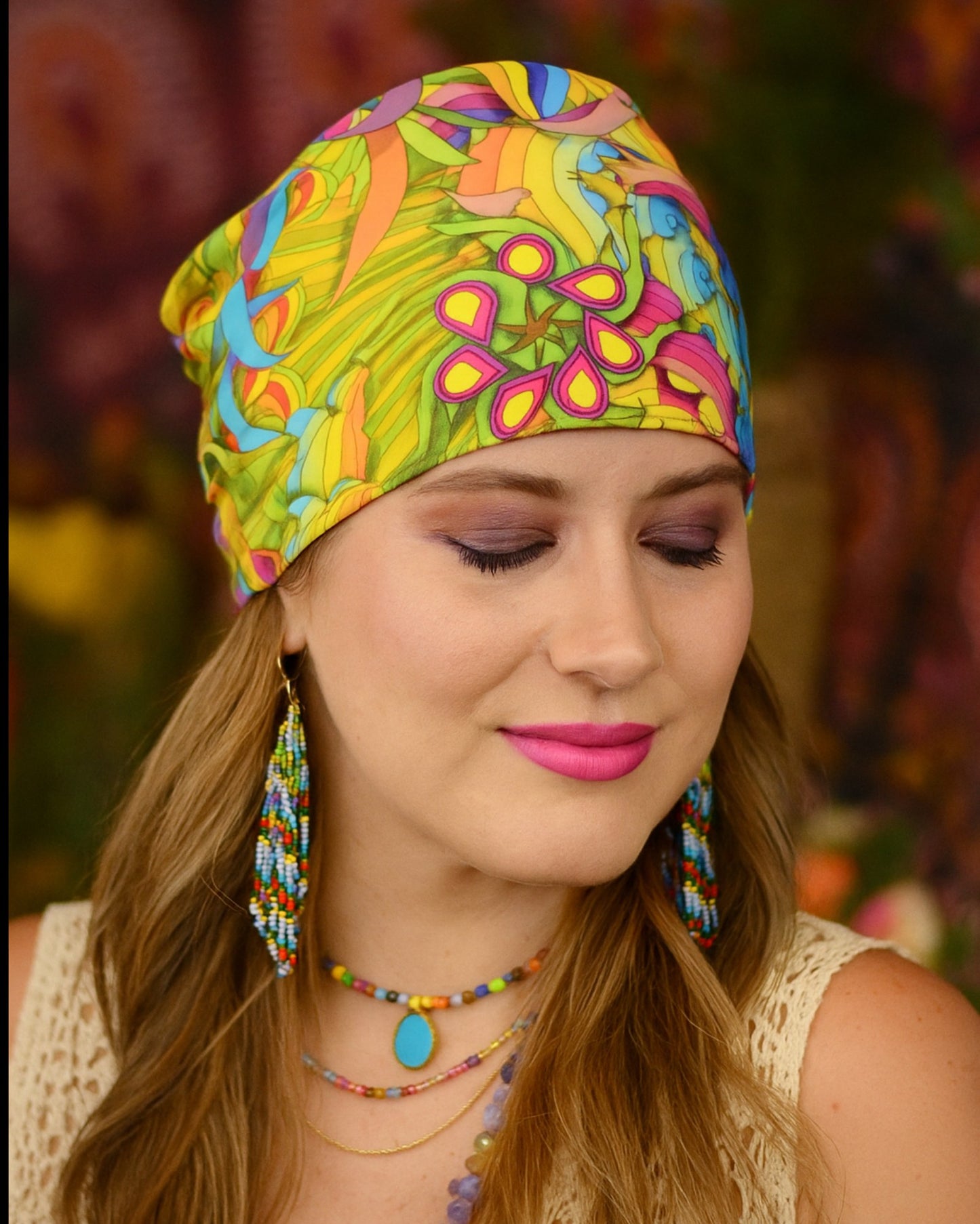 Woman wearing a colorful patterned knotted headband with matching earrings and jewelry.