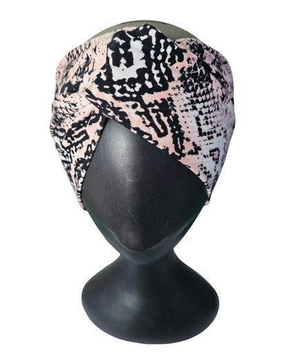 Turban with snake print on a black mannequin head against a white background