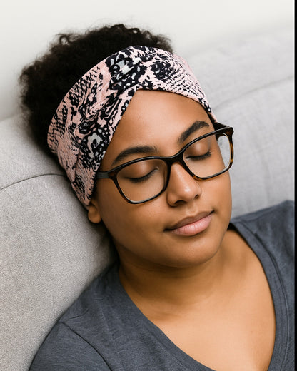 Woman wearing a patterned headband and glasses, sitting on a couch.