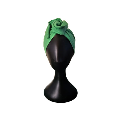 Green headband on a black mannequin head against a white background