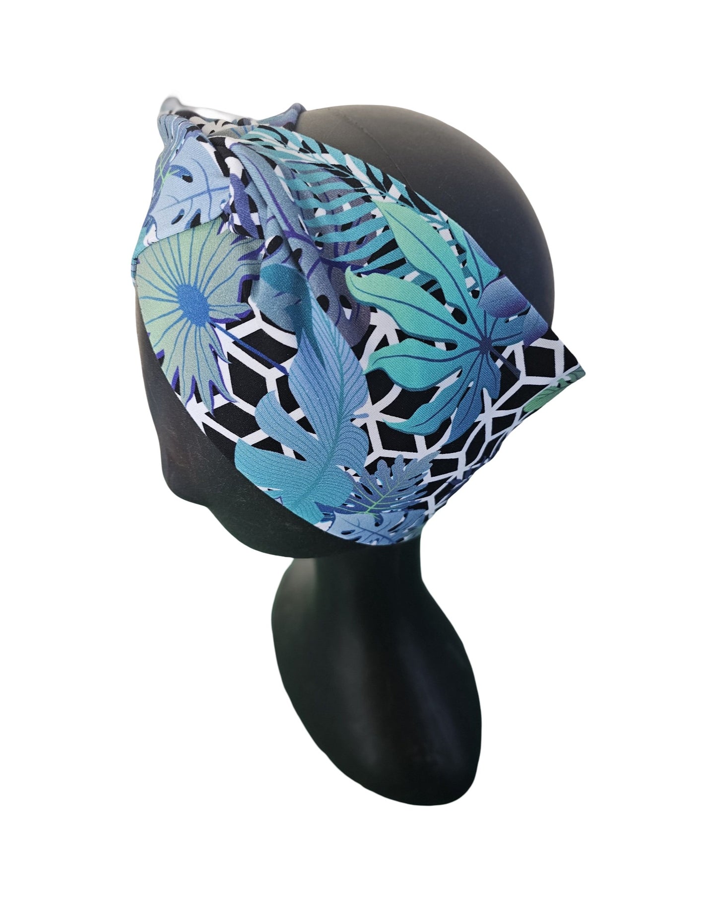 Blue and green patterned ladies knotted headband on a black mannequin head against a white background