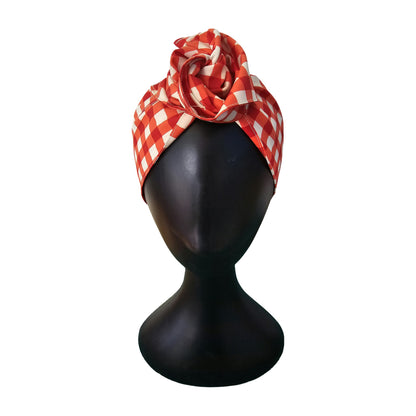 Red and white checkered wire headband on a black mannequin head against a white background