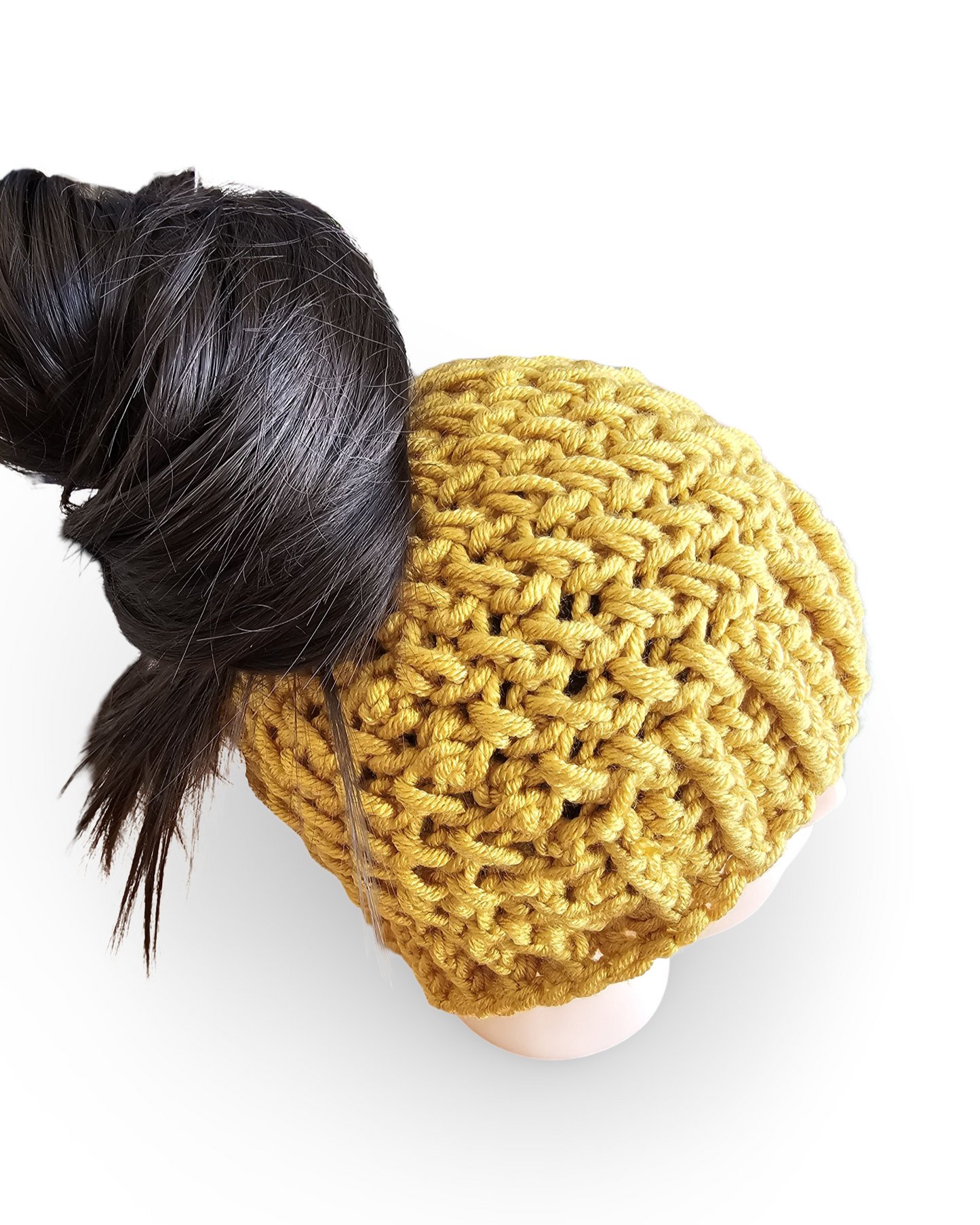 Yellow knitted beanie with a bun on a white background