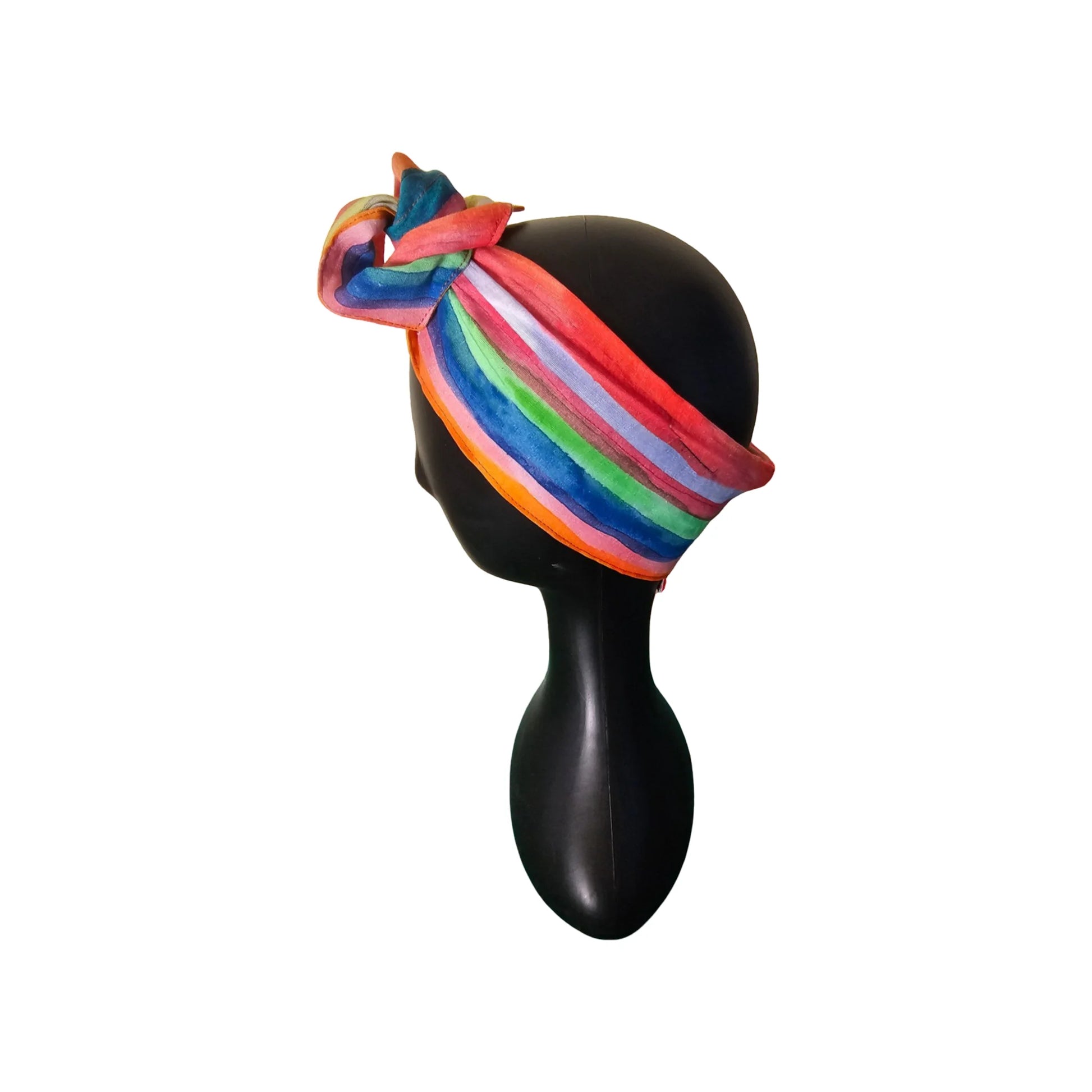 Mannequin head with a colorful striped wire headband on a white background side view